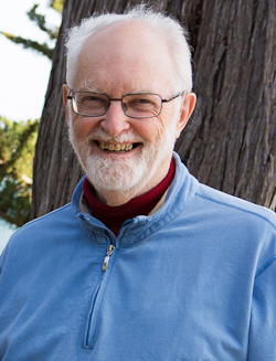 Older man with light skin, white hair and a white beard wearing glasses