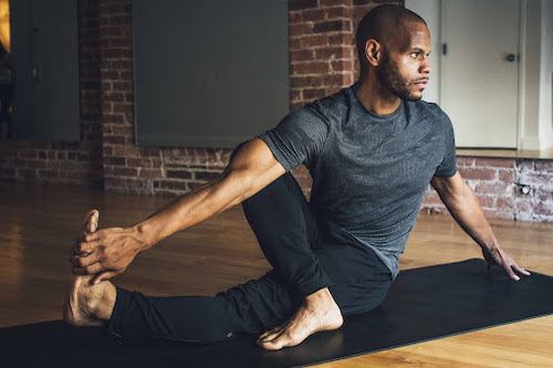 Damien Alexander, yoga teacher in Marichyasana III (Sage’s Pose)