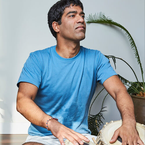 Neil Wadhawan, yoga teacher, playing Indian tabla (musical instrument)